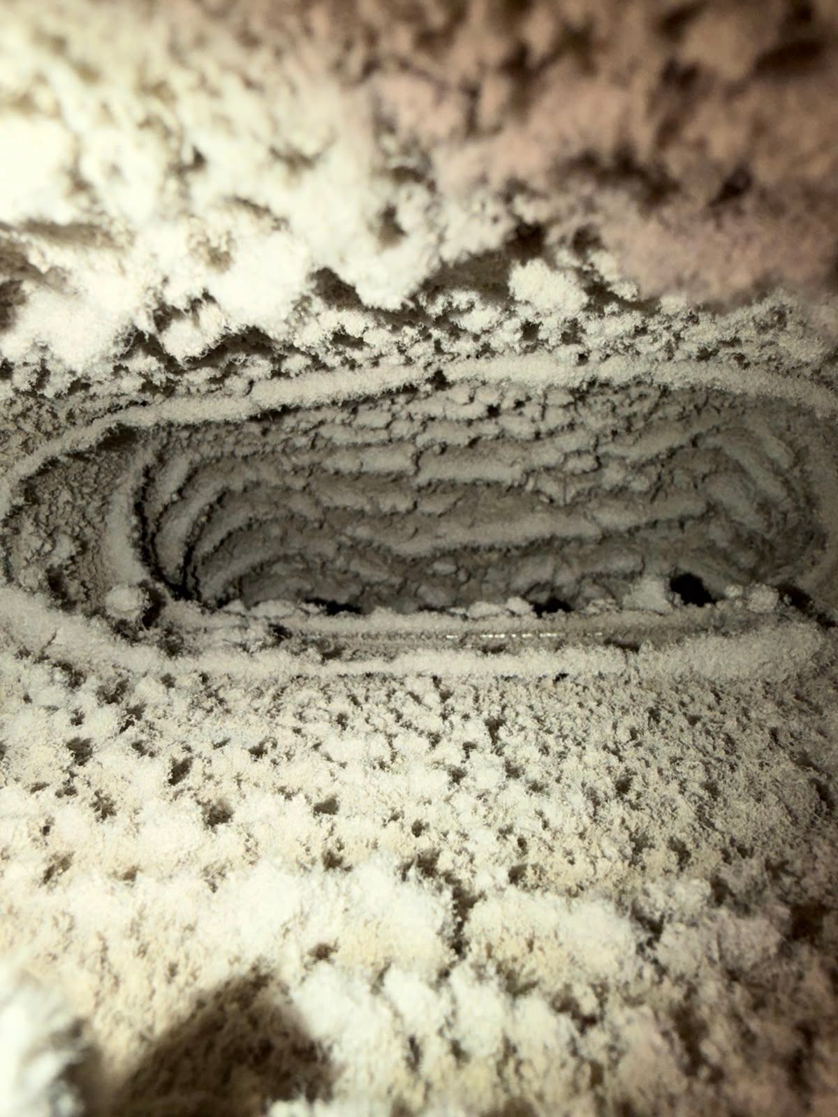 Air duct interior packed with a thick layer of dust and lint before cleaning