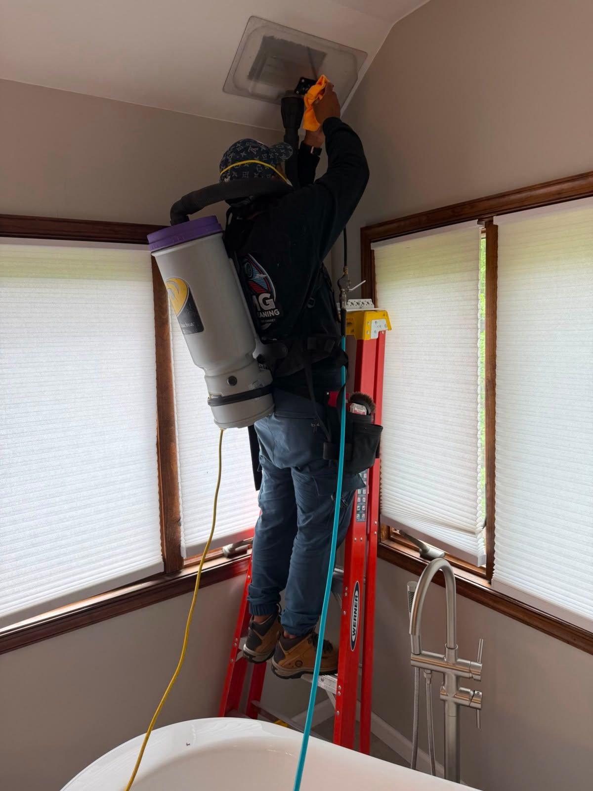 AMG technician working a negative-pressure vacuum line inside a New Jersey home